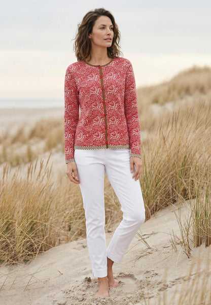 Strickjacke, Modell Lena in tomater Farbnuance mit floralem Muster und Kontrastdetails, frontale Ansicht getragen