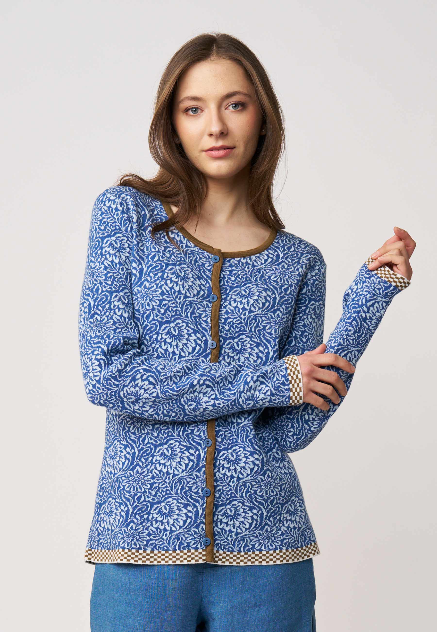 Strickjacke, Modell Lena in Blau mit floralem Muster und Kontrastbesatz an Bündchen und Saum, frontal getragen
