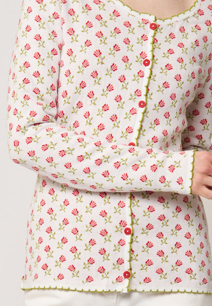 Strickjacke, Modell Lena in cremeweiß mit rotem Rosenmuster und grünem Zierabschluss, frontale Teilansicht getragen