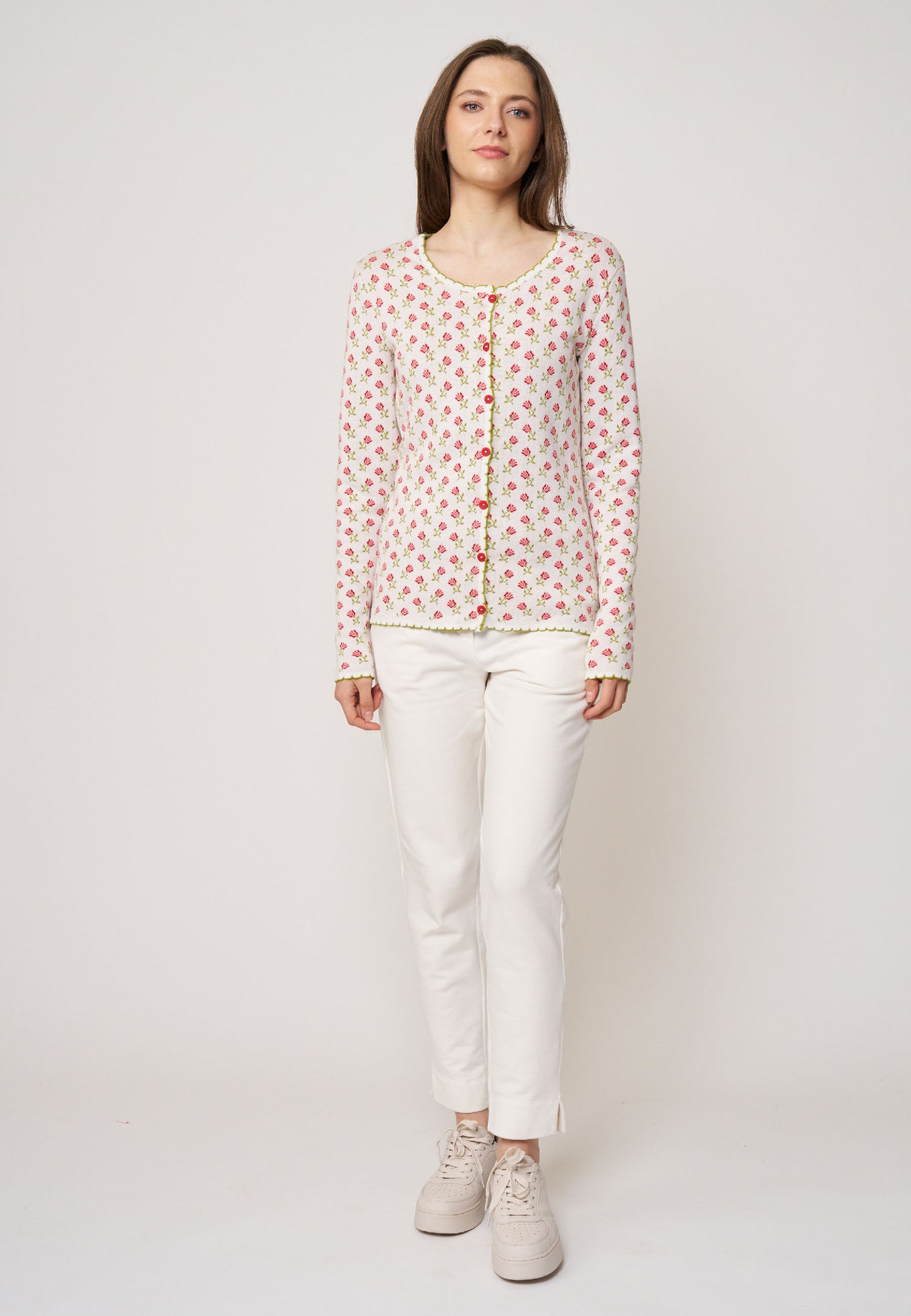 Strickjacke, Modell Lena in Creme mit kleinem rosafarbenem Blumenmuster und grüner Zierkante, frontale Ansicht getragen