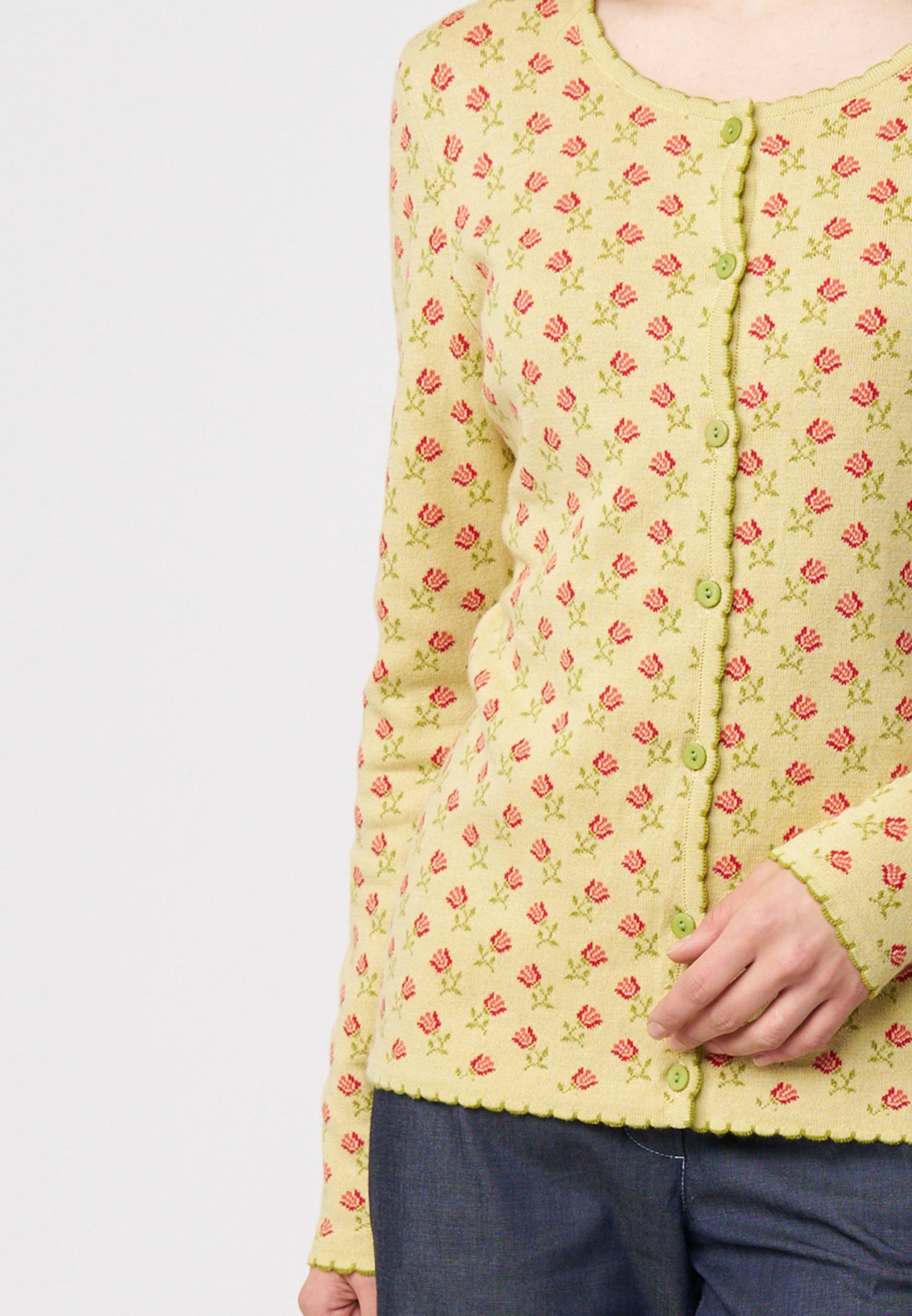 Strickjacke, Modell Lena in hellem Gelb mit kleinem roten Blumenmuster und zarten gerüschten Abschlüssen, Vorderansicht