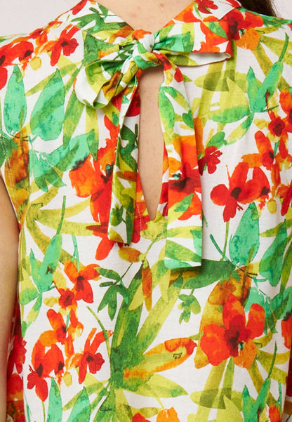 Nahaufnahme des Tops, Modell Ferra, mit buntem floralen Muster und Schleifendetail am Ausschnitt in hellen Farben
