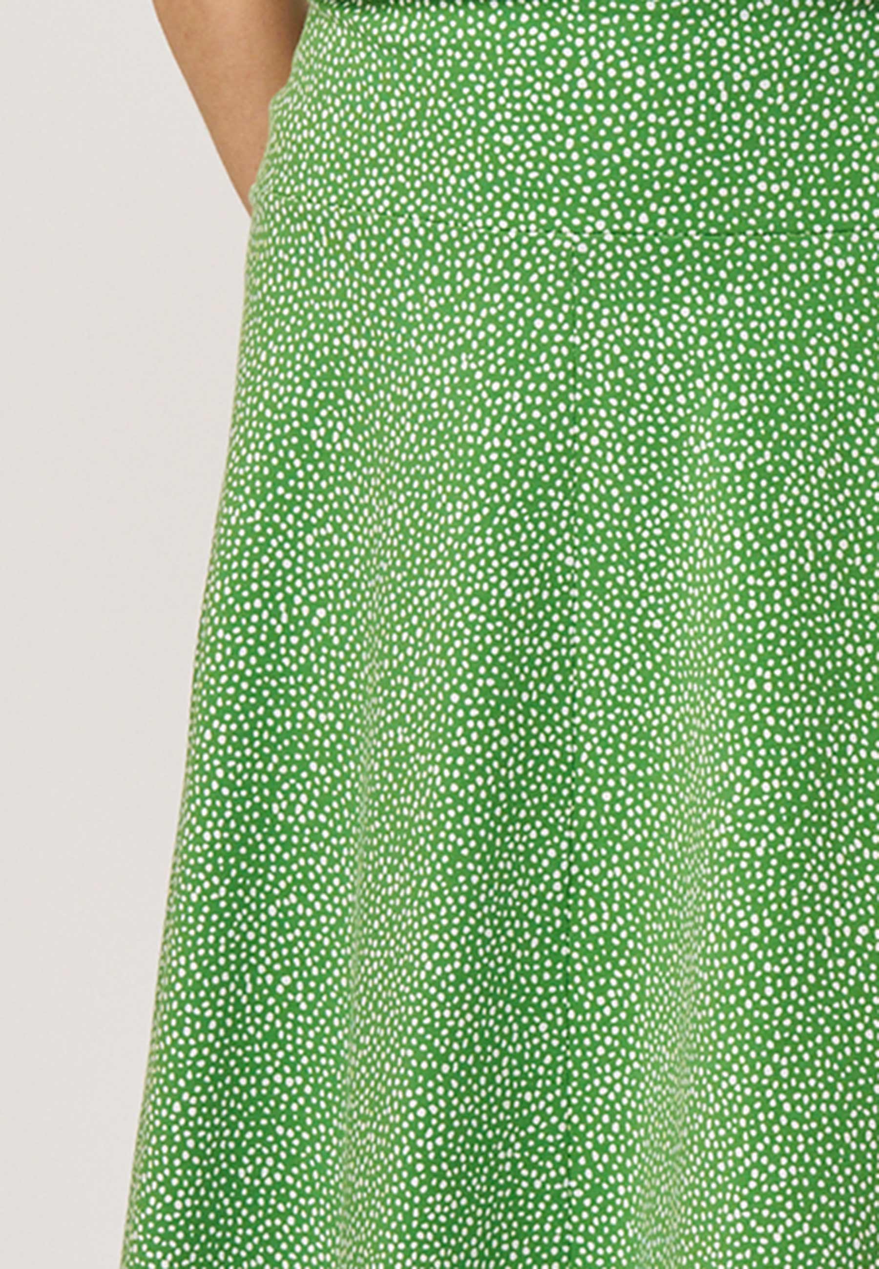 Rock, Modell Mila in lebendigem Grün mit feinem, unregelmäßigem Tupfenmuster und leicht fallendem Schnitt für luftigen Stil
