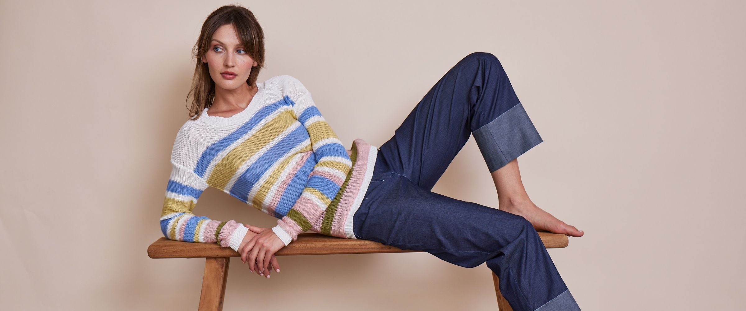 Pulli Gloria in weiß, blau, gold gestreift mit Hosel Raquel in denim blue. Frau liegt auf Bank.